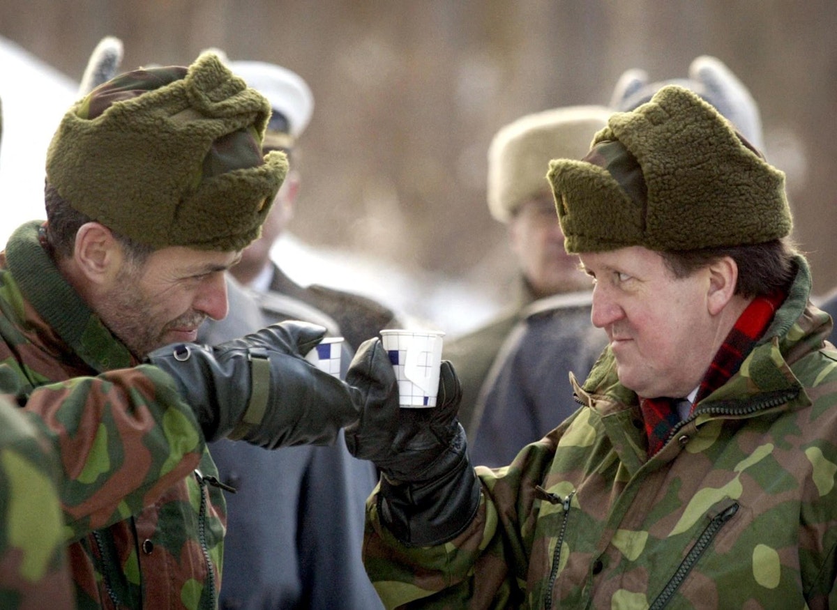 الأمين العام السابق لحلف "ناتو" جورج روبرتسون (يمين) مع وزير الدفاع الفنلندي السابق جان إريك إنستام أثناء زيارة روبرتسون إلى حامية سانتاهامينا، بالقرب من هلسنكي، 30 يناير 2003 - AFP