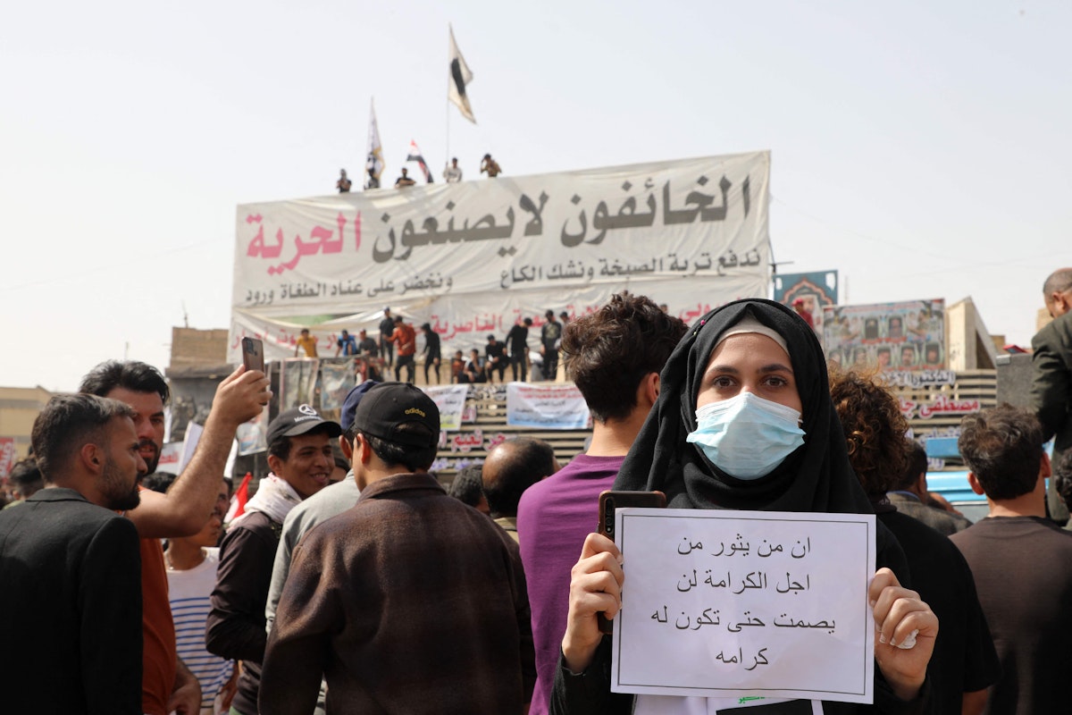 An Iraqi carries a placard which reads in Arabic 