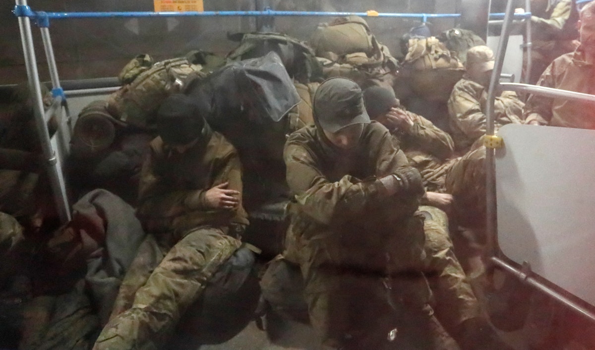 جنود أوكرانيون من مصنع "آزوف ستال" بماريوبل يجلسون في حافلة تحت حراسة الجيش الموالي لروسيا في مستوطنة أولينيفكا في دونيتسك المنطقة. 20 مايو 2022 - REUTERS