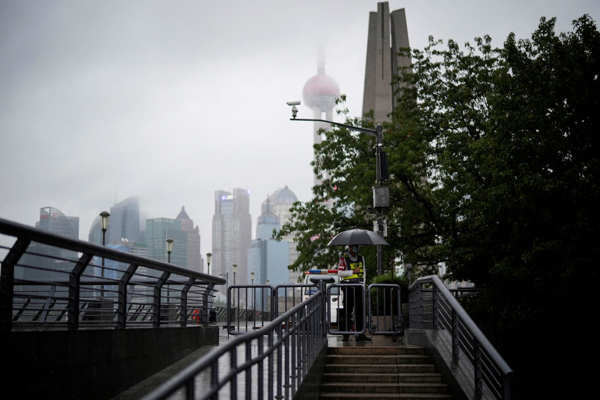 حارس أمن يقف فيما تتساقط الأمطار على مدينة شنغهاي الصين - 14 سبتمبر 2022 - REUTERS