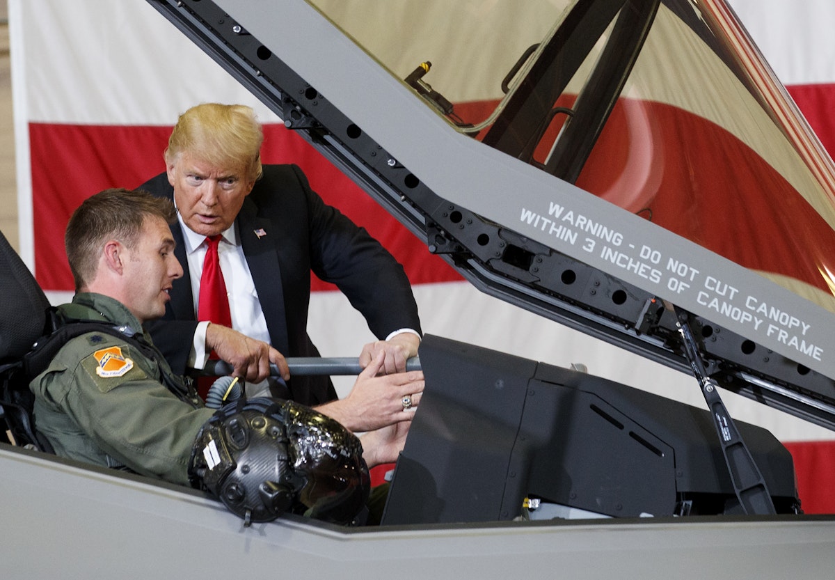 الرئيس الأميركي السابق دونالد ترمب يتحدث إلى طيار في قمرة القيادة لمقاتلة من طراز "إف-35" في قاعدة جوية بولاية أريزونا - 19 أكتوبر 2018 - AP