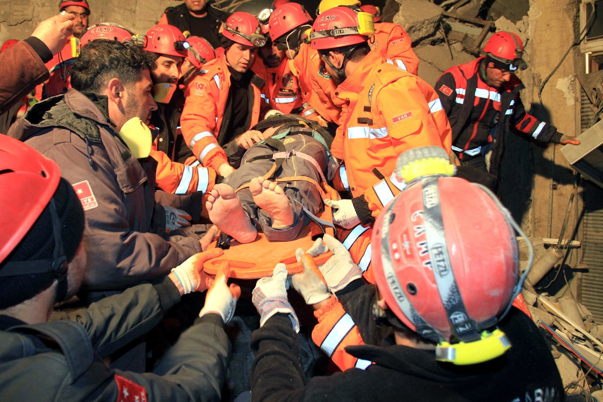 عمال إنقاذ ينقلون أحد الناجين من مبنى منهار بعد زلزال في وان شرقي تركيا. 9 نوفمبر 2011 - AFP